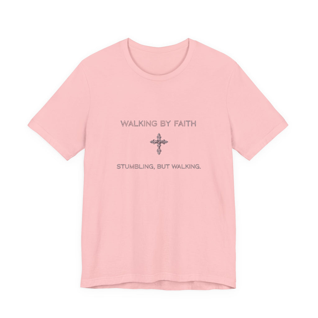 Pink t-shirt with text 'Walking by Faith, Stumbling, but Walking' on a white background