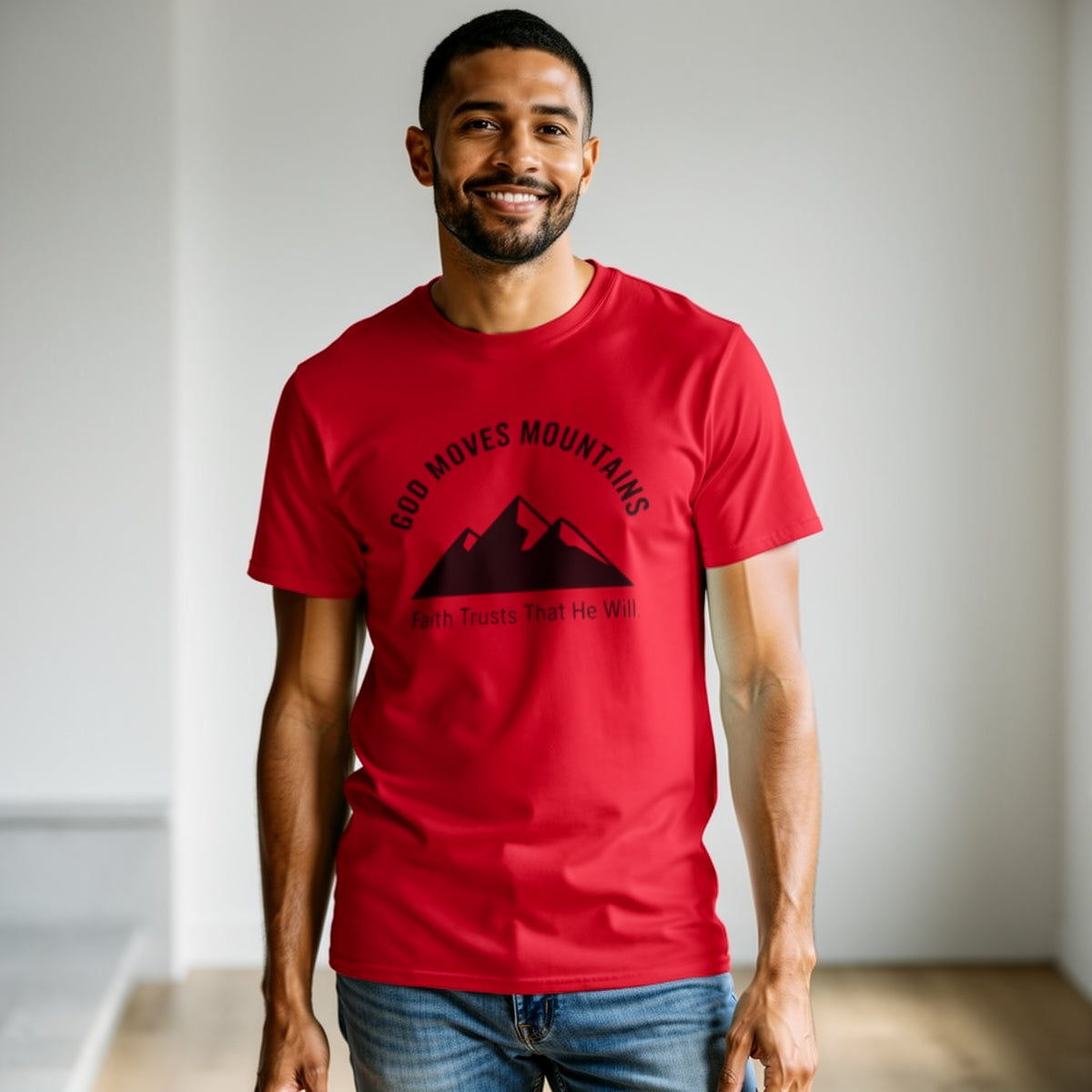Man wearing a red t-shirt with a graphic design and text, standing indoors.
