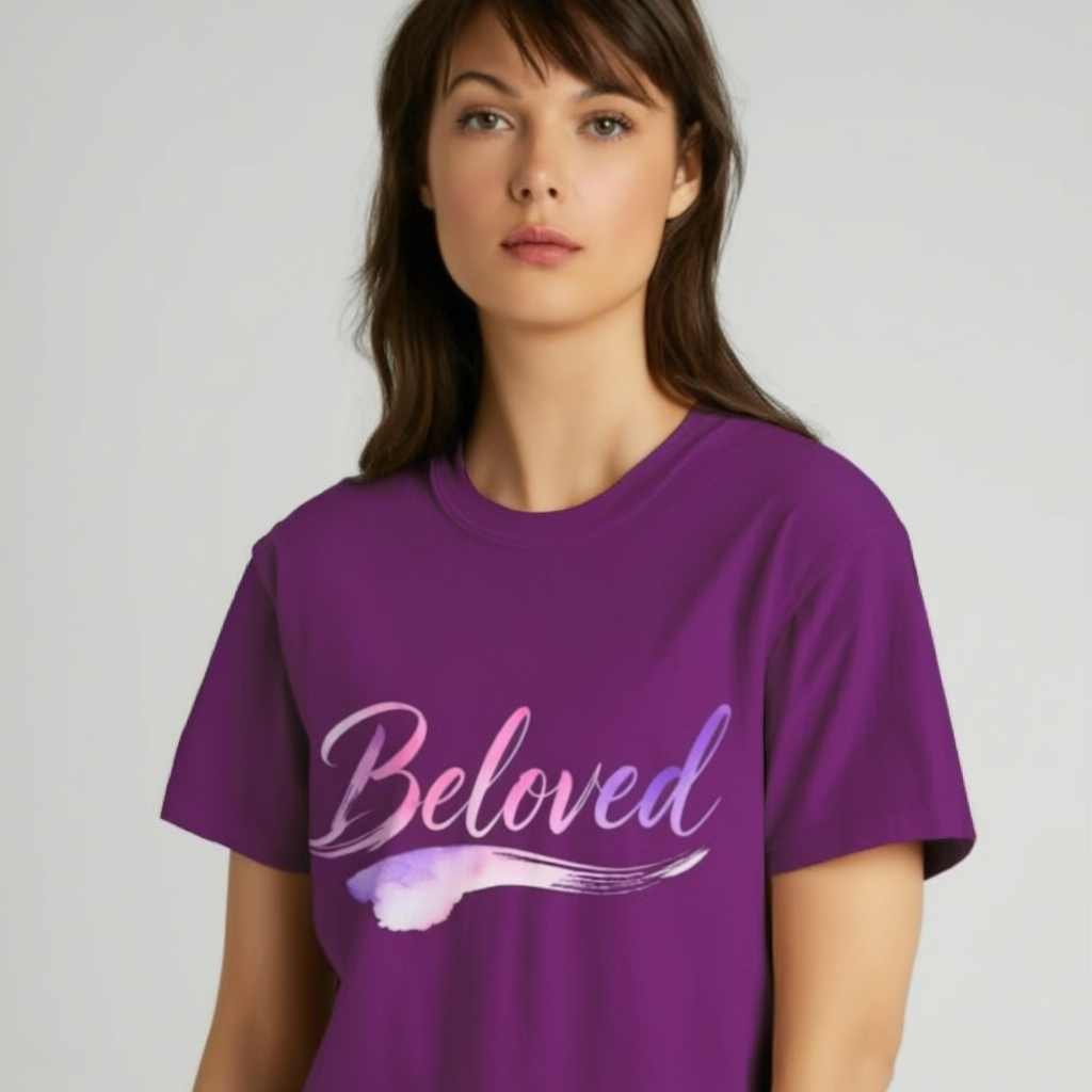 Woman wearing a purple t-shirt with 'Beloved' printed on it against a plain background