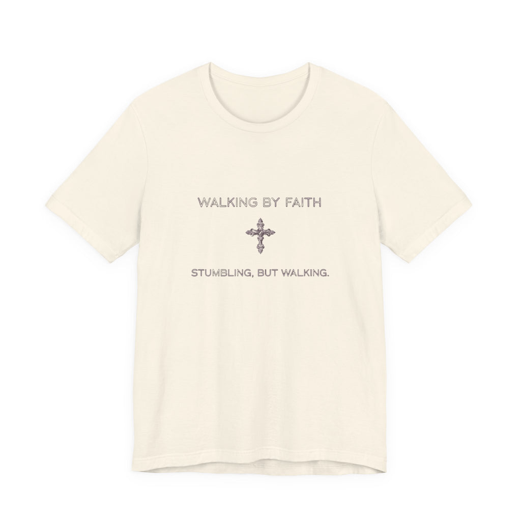 Beige t-shirt with text 'Walking by Faith, Stumbling, But Walking' on a white background