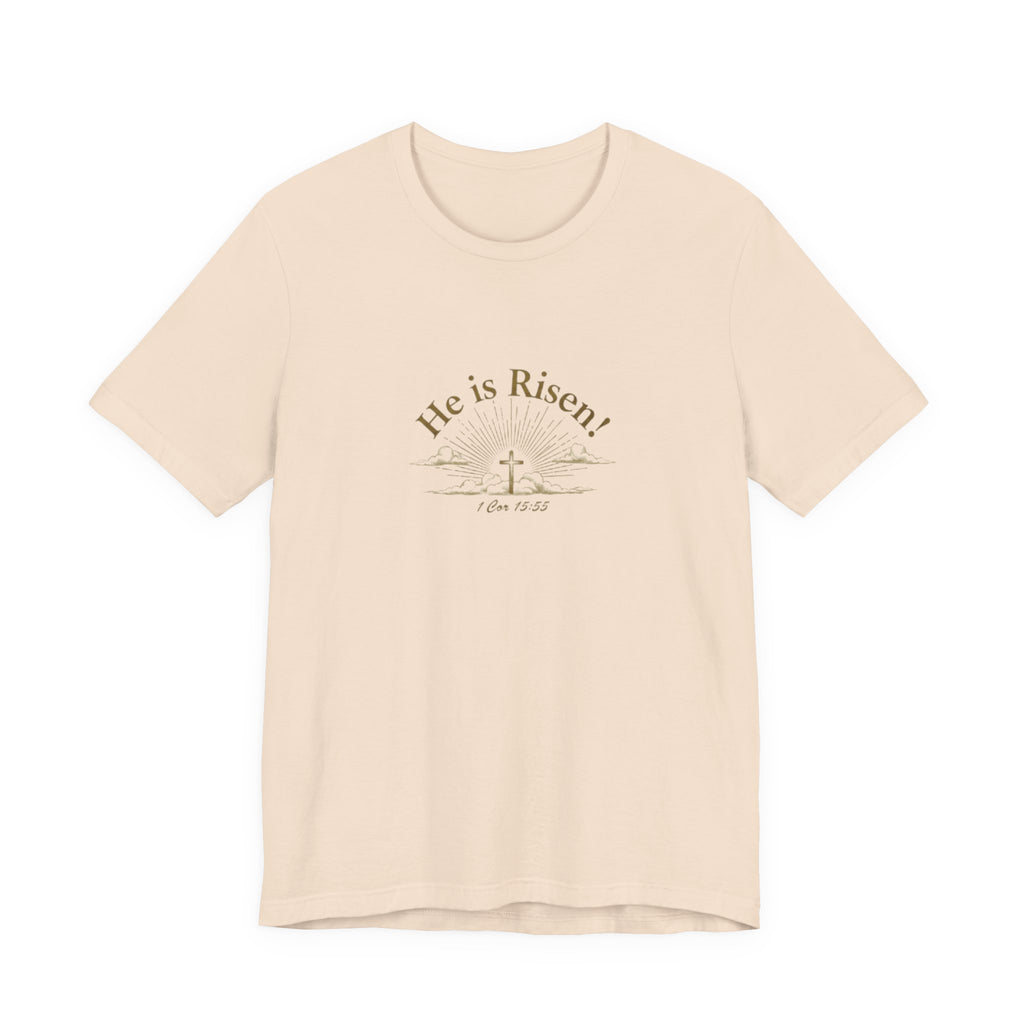 Beige t-shirt with 'He is Risen!' text and cross graphic on a white background