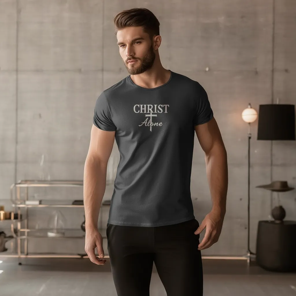 Man wearing a dark gray t-shirt with CHRIST ALONE in a modern interior setting