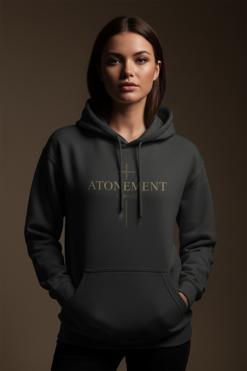 Female model wearing Atonement Pullover Hoodie in Charcoal — editorial style front view, 1 John 2:2 atonement design, premium faith-based hoodie by 4HG