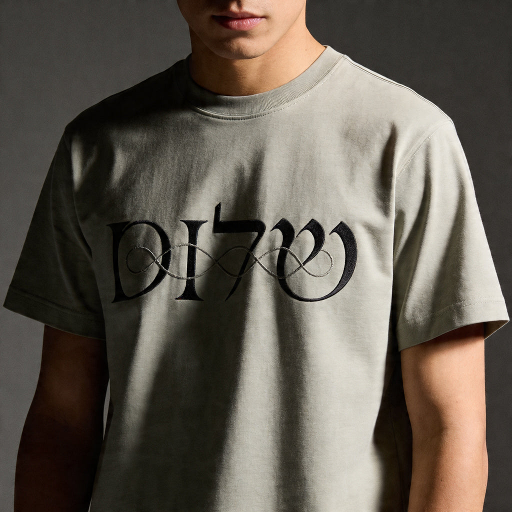 Person wearing a gray t-shirt with black text on a dark background