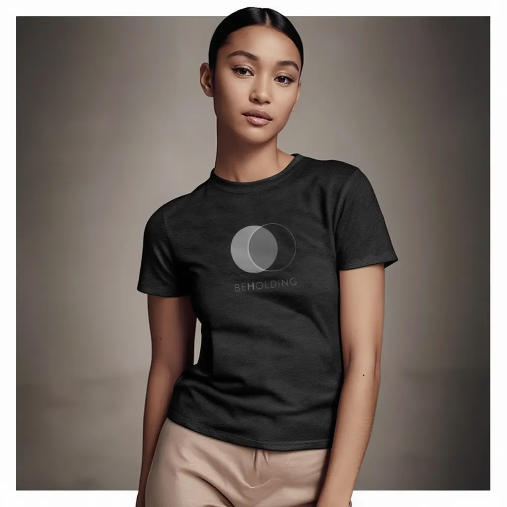 Female model wearing Beholding Is Becoming Men's Faded Tee in Faded Black — editorial style, 2 Corinthians 3:18 scripture design, Christian apparel by 4HG