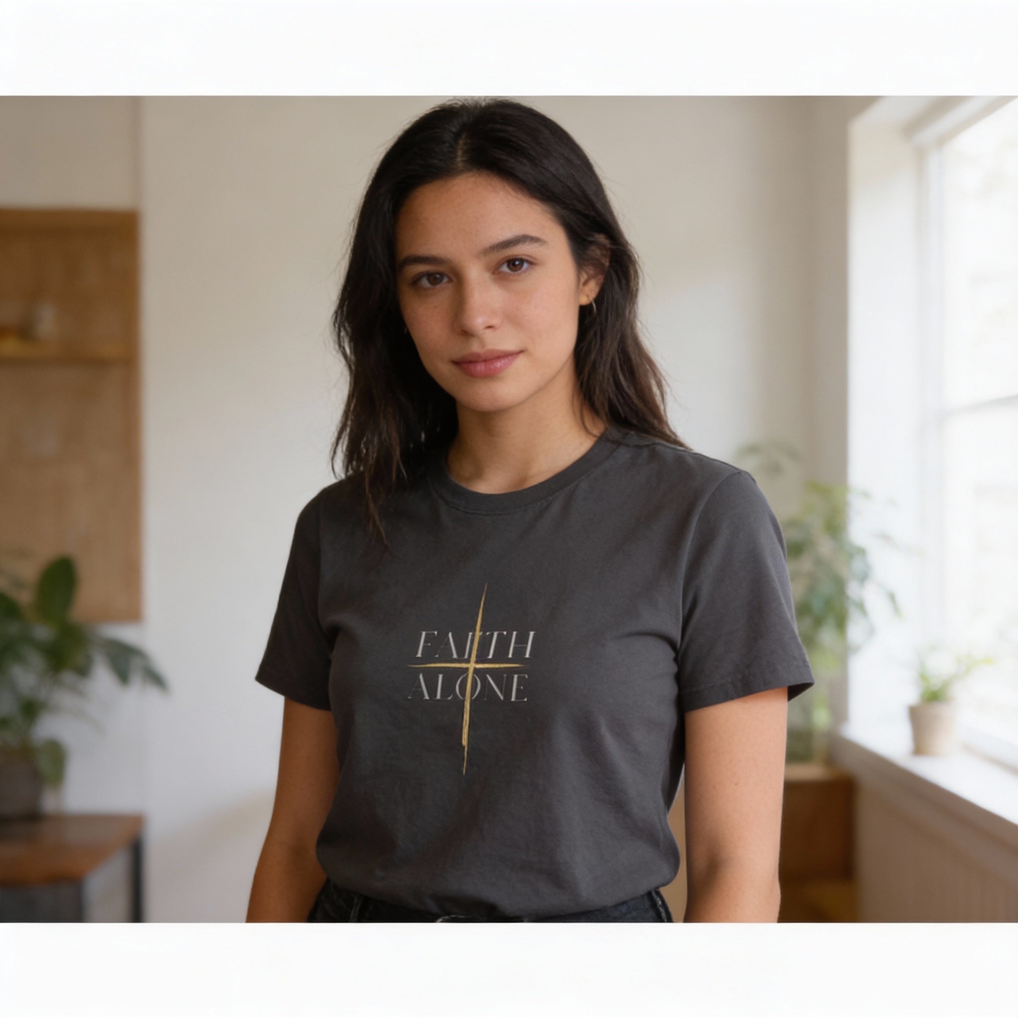 Woman wearing a dark gray t-shirt with 'FAITH ALONE' text in a home setting
