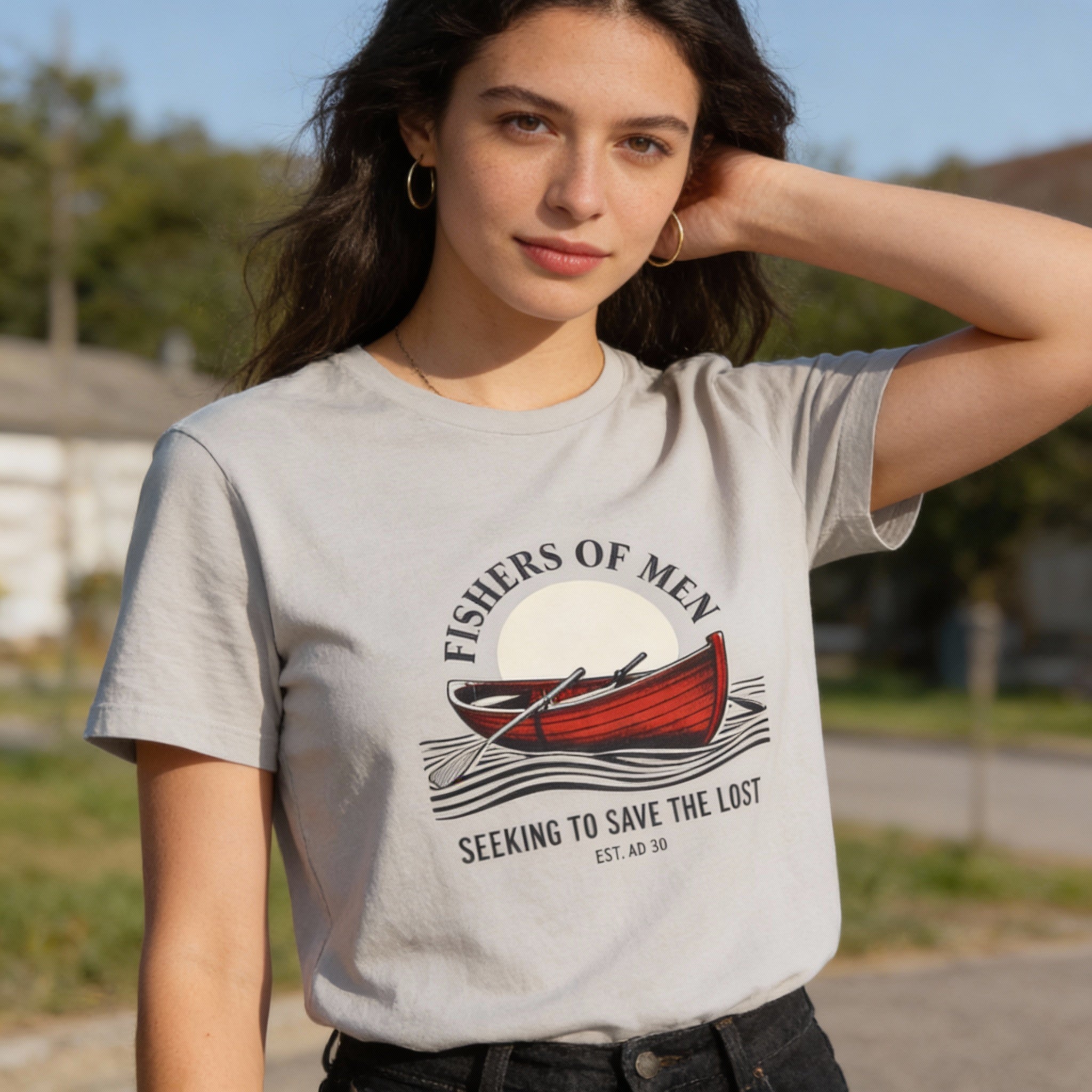 Woman wearing a gray t-shirt with a graphic design outdoors