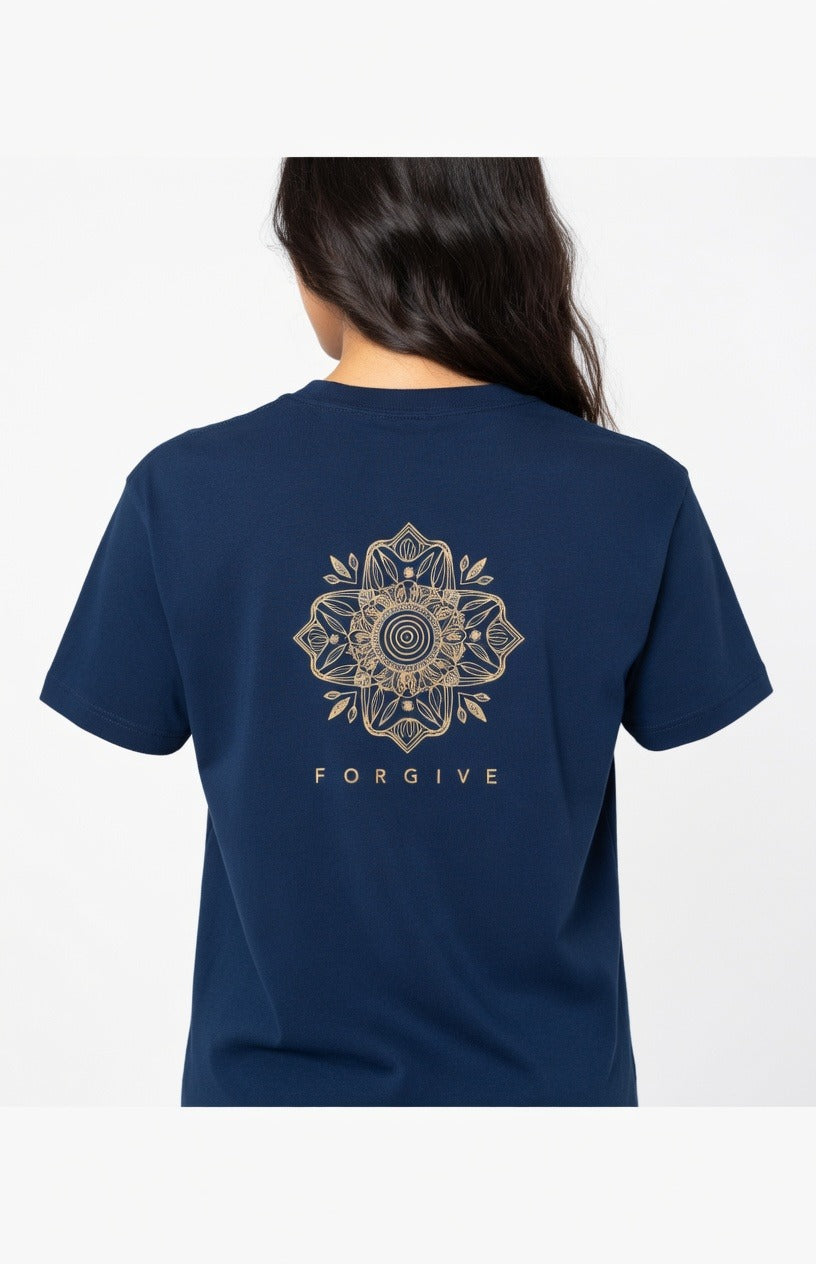 A woman viewed from the back wearing a navy blue short-sleeve T-shirt with a large gold mandala graphic and the word 'FORGIVE' printed below it.