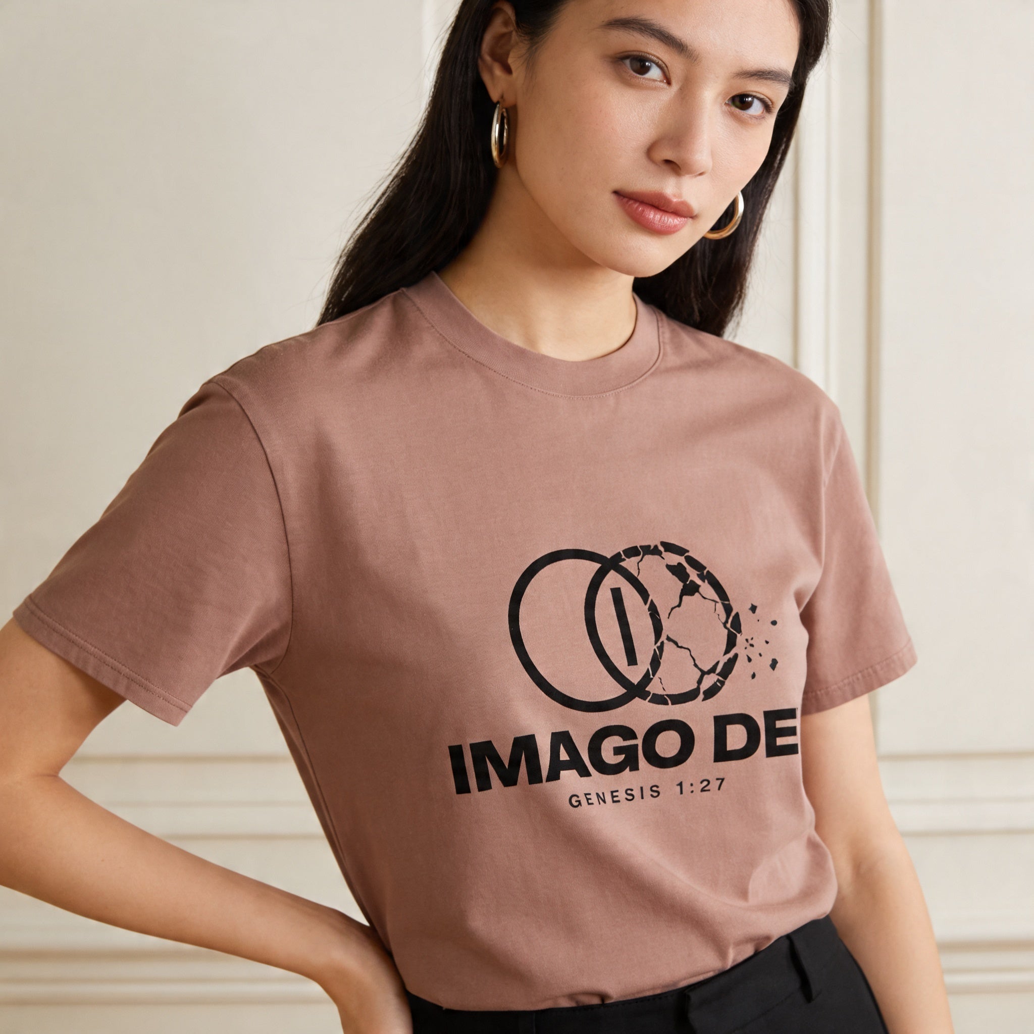 Person wearing a faded pink t-shirt with 'IMAGO DEI' logo and text.