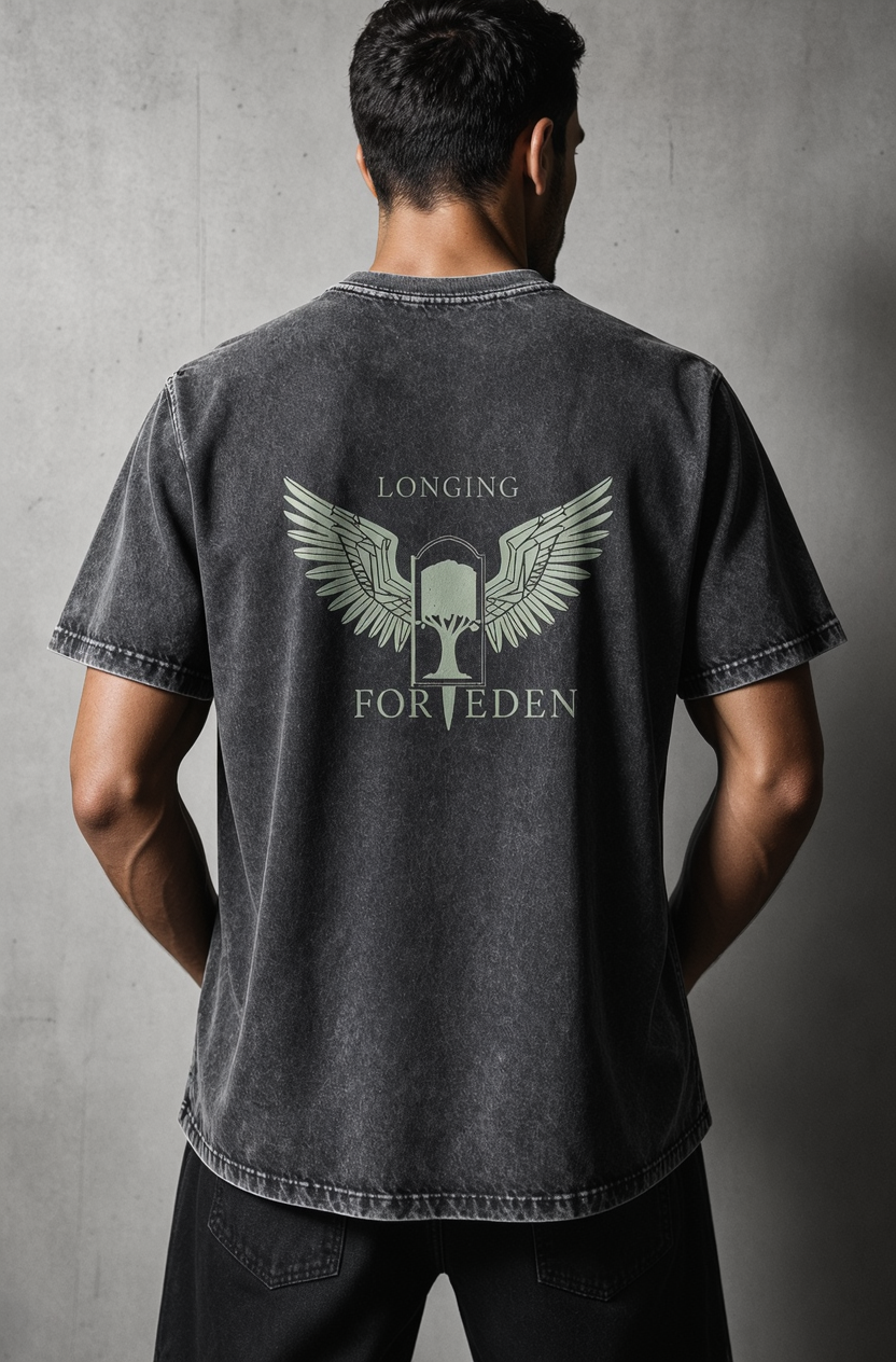 Person wearing a black t-shirt with 'Longing for Eden' design on the back against a gray background