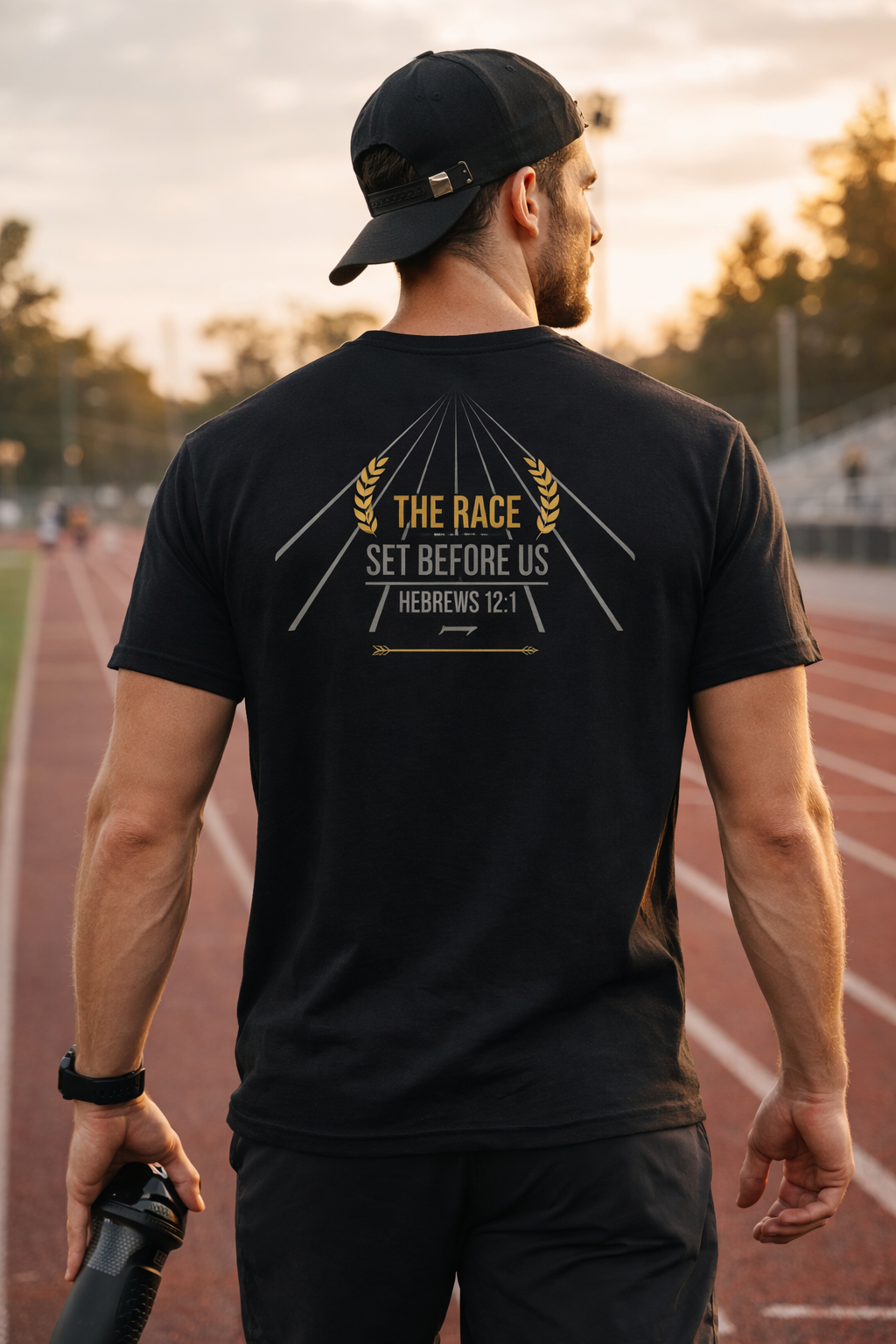 Man wearing a black t-shirt with a motivational quote on a running track