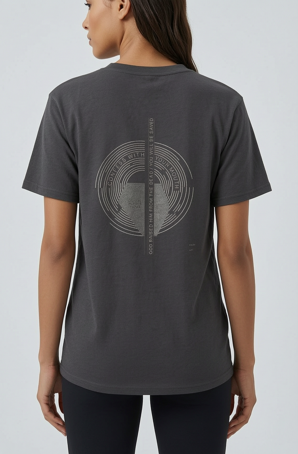 Person wearing a dark gray t-shirt with a circular design on the back against a light gray background