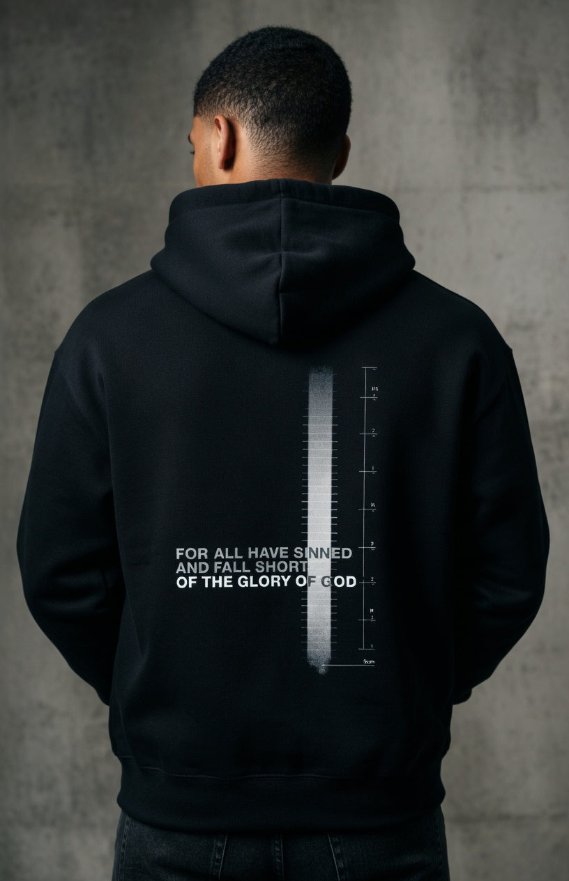 Person wearing a black hoodie with text and design on the back against a gray background