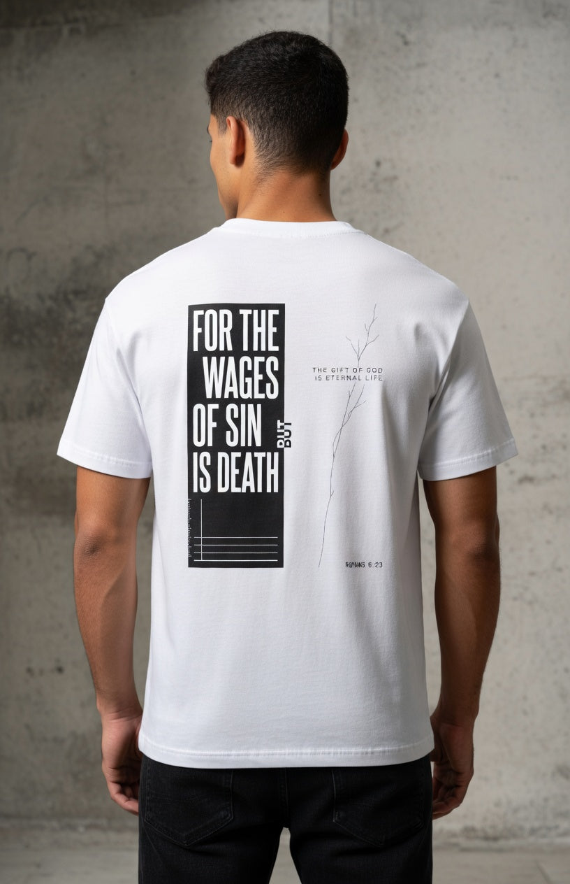 Person wearing a white t-shirt with text on the back against a gray concrete wall.