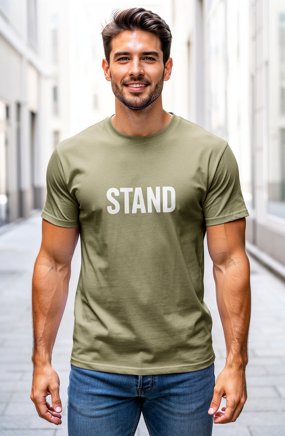 Man wearing a green t-shirt with 'STAND' text in an urban setting